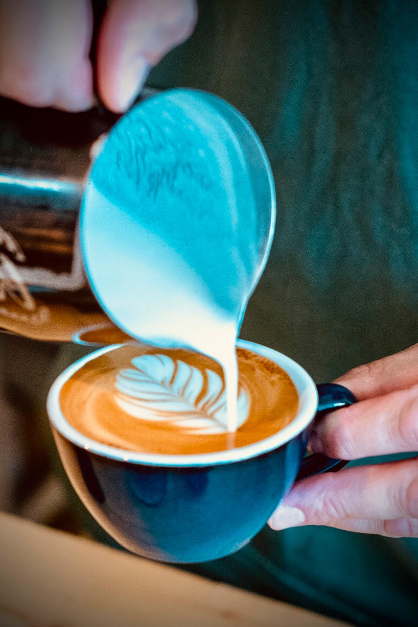 Barista schenkt latte art in een kop koffie